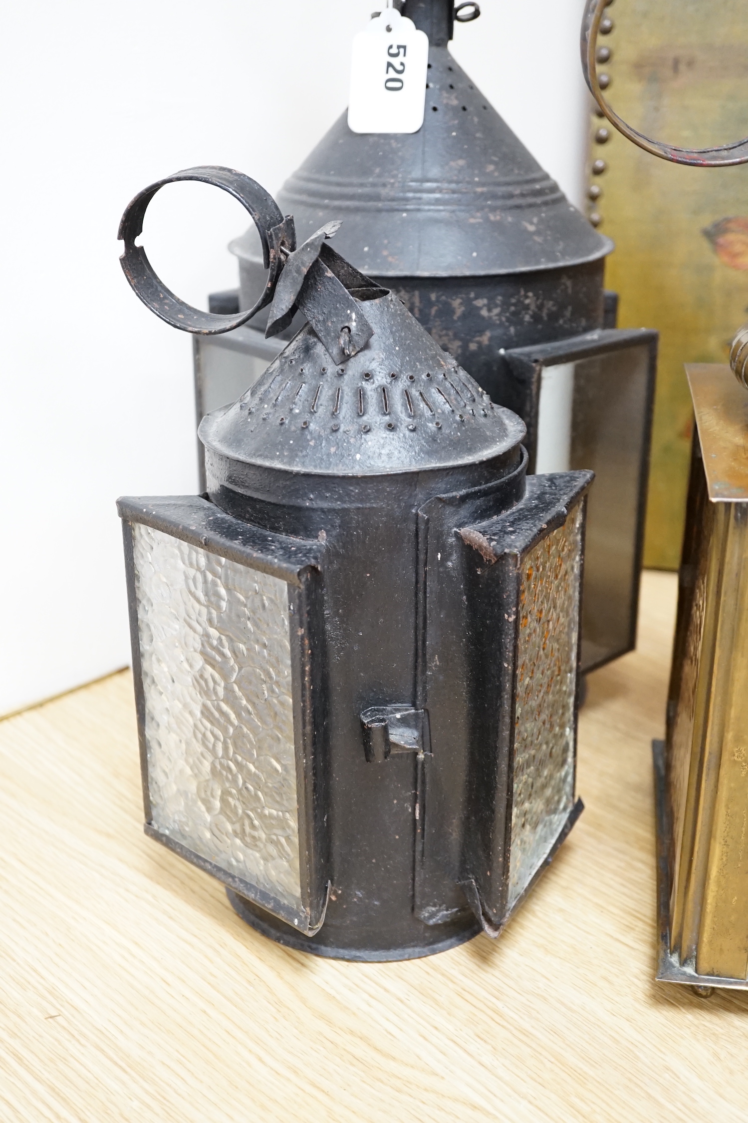 Three 19th century candle lanterns, one brass 45cm high, two black painted steel 45cm & 35cm high